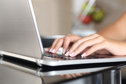 Close up of a woman hands working with a laptop at home